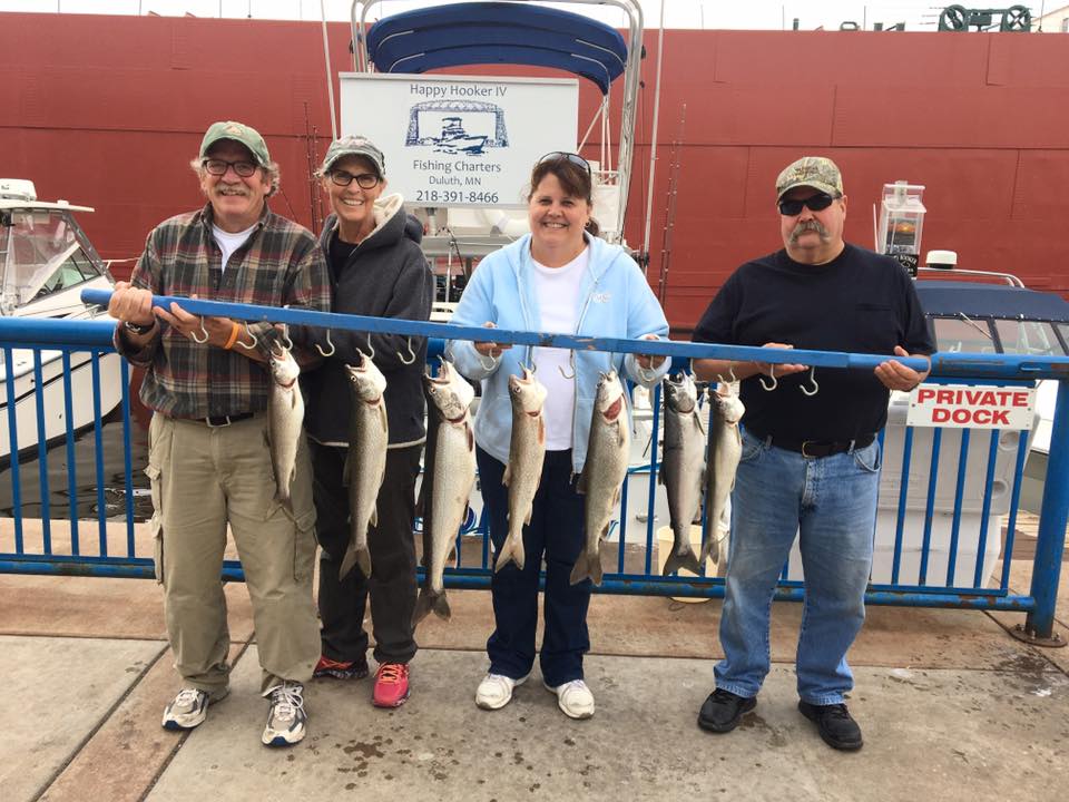 people holding fish they caught on a fishing charter